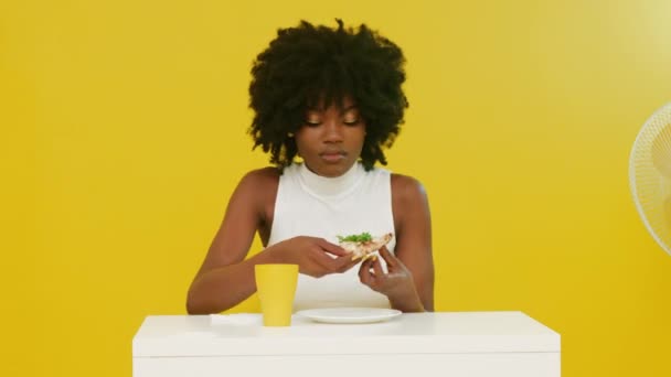 Mujer negra está comiendo pizza con rúcula - Imágenes, Vídeo