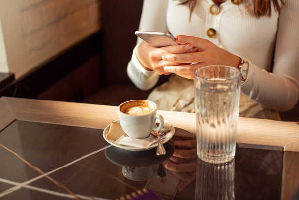 Woman texting on the smartphone in the cafe bar - Φωτογραφία, εικόνα
