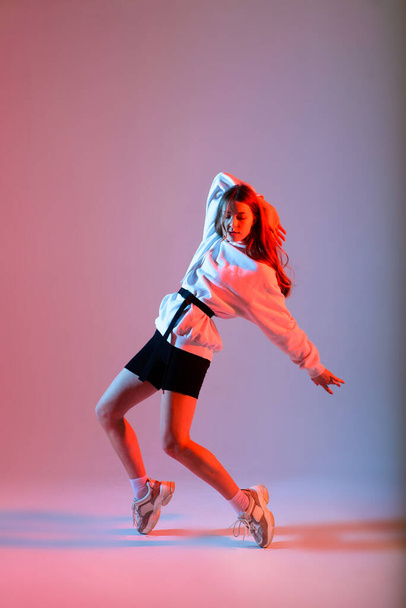 Nastoletnia tańcząca kobieta hip-hop w studio, luźne ubrania - Zdjęcie, obraz