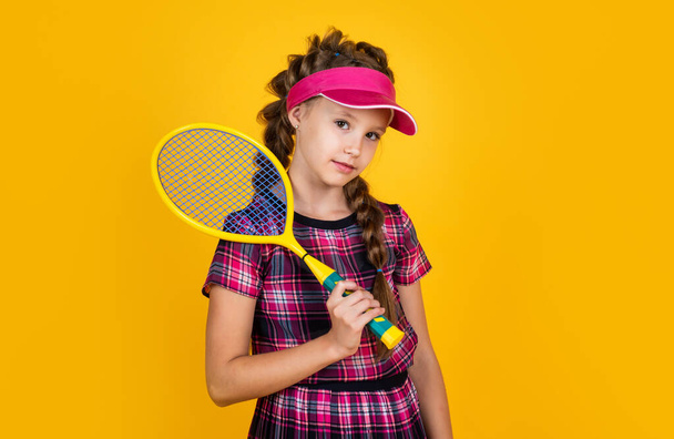 full of energy. happy childhood. kid in cap hold racket. child with racquet. teen girl do sport training. dedicated to fitness. tennis or badminton player. healthy and active lifestyle. Sport success - Zdjęcie, obraz