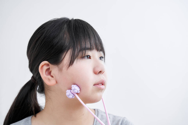 Gimnazjum Japońskie dziewczyny masaż z małym rolki twarz - Zdjęcie, obraz