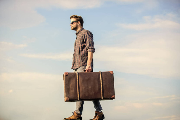 Man carrying his things in baggage. Business trip. Handsome guy traveler. Travel with luggage. Vacation time. Guy outdoors with vintage suitcase. Luggage concept. Travel agency. Travel blogger - Foto, afbeelding