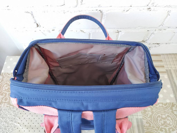 Відкритий синьо-рожевий рюкзак на столі, ізольований
 - Фото, зображення