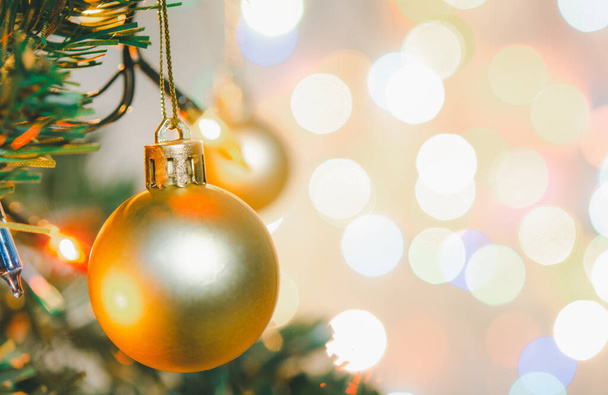 Decoración de Navidad. Bolas de oro colgando en ramas de pino Guirnalda de árbol de Navidad y adornos sobre fondo bokeh abstracto con espacio de copia - Foto, Imagen
