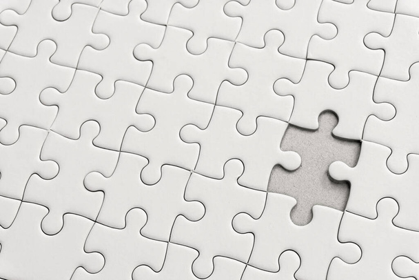 White jigsaw puzzle pattern background. placing last piece of jigsaw puzzl - Photo, image