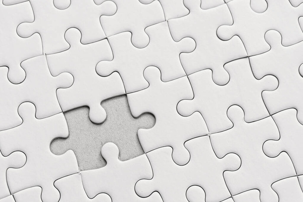 White jigsaw puzzle pattern background. placing last piece of jigsaw puzzl - Photo, image