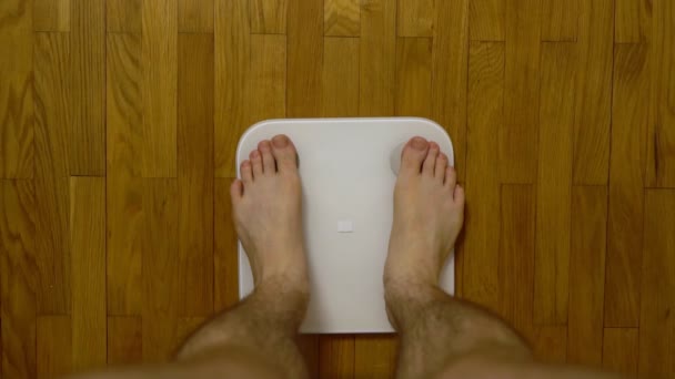Legs on the scales. Man checking his weight. - Footage, Video