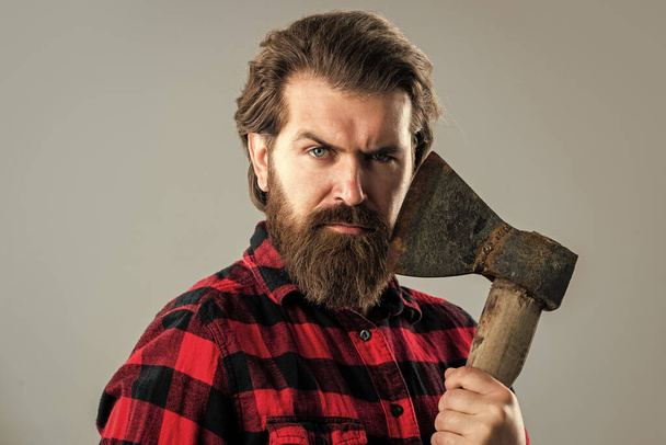 bearded man with axe. cut hair with ax. male hairdresser or barbershop. brutal butcher in shirt. lumberjack ready to work in forest. confident brutality of woodman. woodcutter use ax - Foto, afbeelding