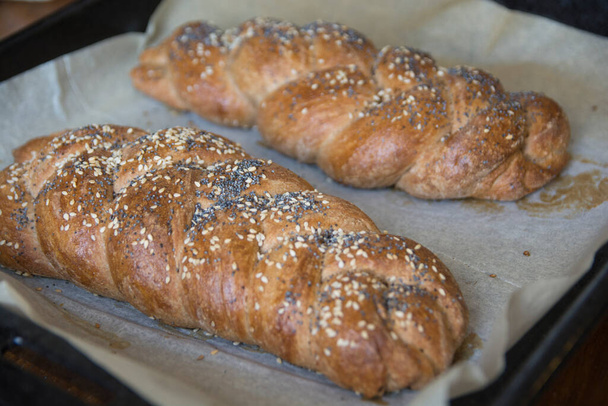 Geleneksel fırınlanmış Challah ekmeği, hecelenmiş undan yapılmış, susam ve haşhaş tohumlu. - Fotoğraf, Görsel