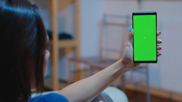 Huisvrouw met smartphone met groen scherm - Foto, afbeelding