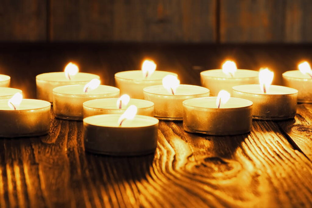 Burning candles. Shallow depth of field. Many christmas candles burning at night. Abstract candles background. Many candle flames glowing on dark background. Close-up. Free space. - Photo, Image
