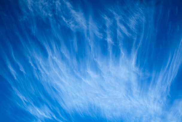 Reproduction photographique d'une journée avec un ciel bleu et des nuages blancs en couches - Photo, image