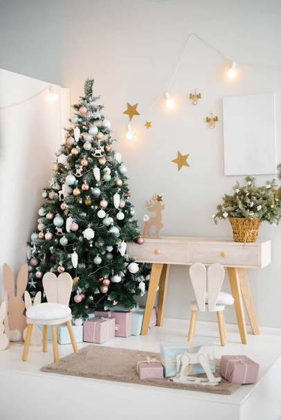 明るい色のクリスマスツリー、椅子、おもちゃ付きの居心地の良い明るい子供部屋 - 写真・画像