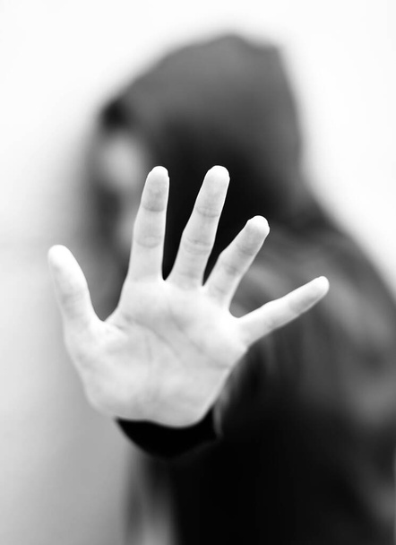 mano de la joven con la sudadera que se protege con un efecto blanco y negro - Foto, imagen