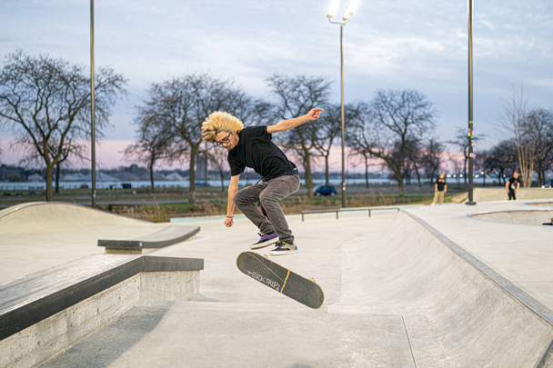 skaters and bikers practice tricks at an outdoor skate park in Detroit, Michigan / USA - November 19 -2020 - Foto, imagen