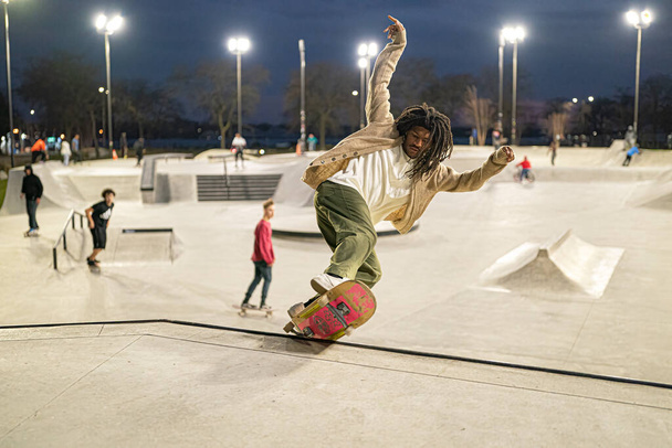 Skater und Biker üben Tricks in einem Outdoor-Skatepark in Detroit, Michigan / USA - 19. November -2020 - Foto, Bild