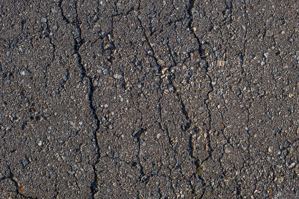 cracked across flat asphalt texture with hard direct sunlight - Фото, зображення