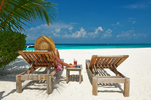 Woman at beach with chaise-lounges - Photo, Image