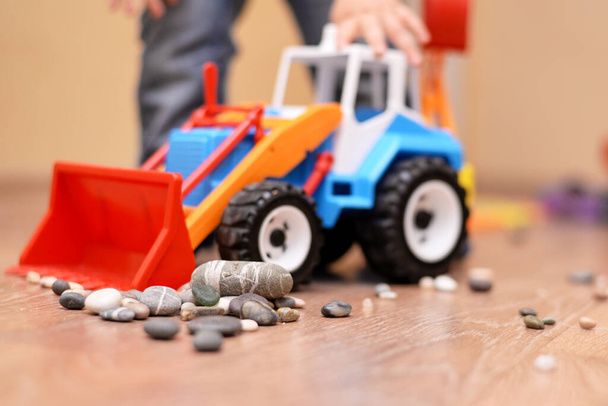 Kleurrijke speelgoed trekker met stenen op de vloer in de kamer, educatief speelgoed voor kinderen. - Foto, afbeelding