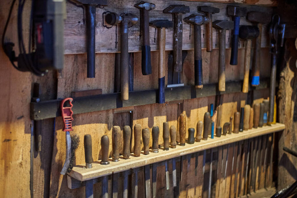 Ferramentas velhas - martelos e arquivos de tamanhos diferentes em uma parede de madeira. - Foto, Imagem