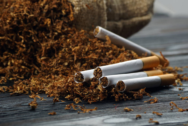 suchý tabákový list a cigarety na dřevěném stole. zavřít - Fotografie, Obrázek