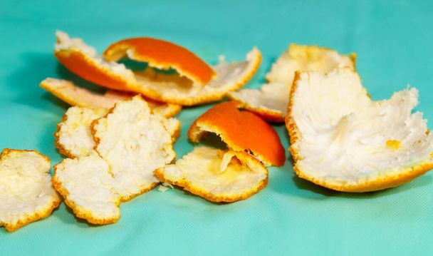 Cáscara de cítricos, naranjas y mandarinas sobre fondo turquesa. Primer plano, marco horizontal. - Foto, imagen