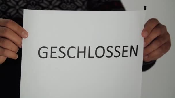 Працівник вивішує інформаційний знак "Geschlossen".. - Кадри, відео