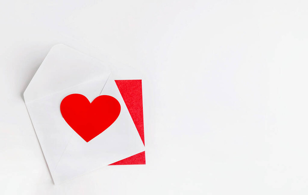 Valentin en papier rouge en forme de coeur sur enveloppe blanche. espace de copie. - Photo, image