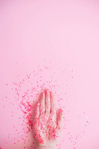 Hand in glitter on pink pastel background . High quality photo - Photo, Image