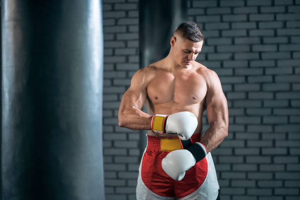strong sportsman boxer exercising in white gloves at gym - Photo, Image