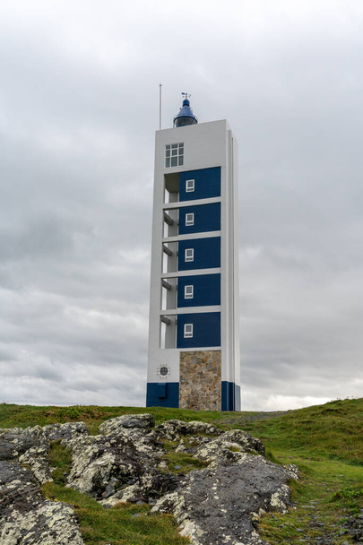 the modern Punta Frouxeira lighthouse under a gray stormy overcast sky - Foto, afbeelding