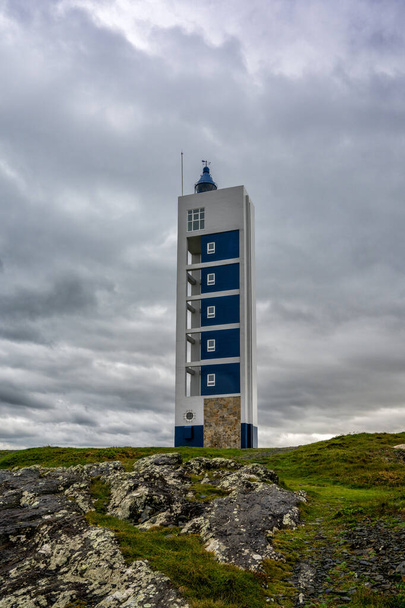 the modern Punta Frouxeira lighthouse under a gray stormy overcast sky - Foto, Imagen
