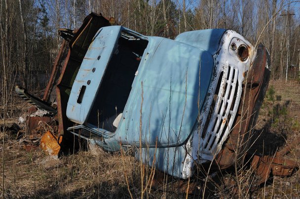 Abandoned radioactive vehicle, old rusty truck near ghost town Pripyat, post apocalyptic city, spring season in Chernobyl exclusion zone, Ukraine - Photo, Image