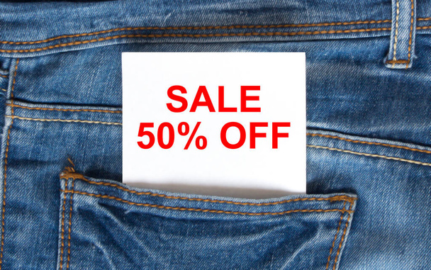 Κείμενο Πώληση 50 off σε λευκό χαρτί στην τσέπη του μπλε τζιν τζιν. Μπορεί να χρησιμοποιηθεί ως έννοια μάρκετινγκ - Φωτογραφία, εικόνα