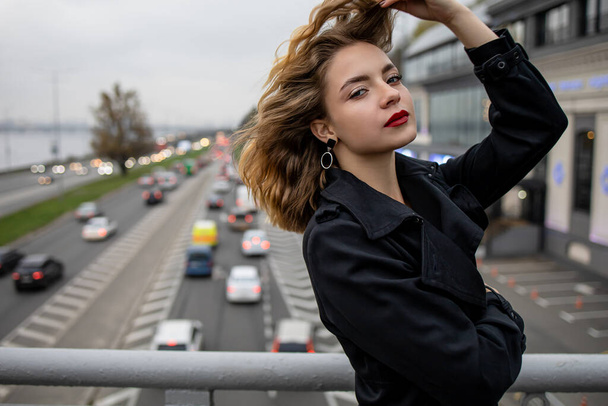 Beautiful Caucasian woman leaning on a bridge over the highway In Winter Time. - Fotoğraf, Görsel