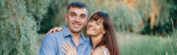 Gyönyörű mosolygós házas pár férfi nő szerelmes. Férj és feleség ölelkeznek a parkban a nyári napon. Összetartás és boldogság. Hiteles igazi család a szabadban. Web banner fejléc. - Fotó, kép