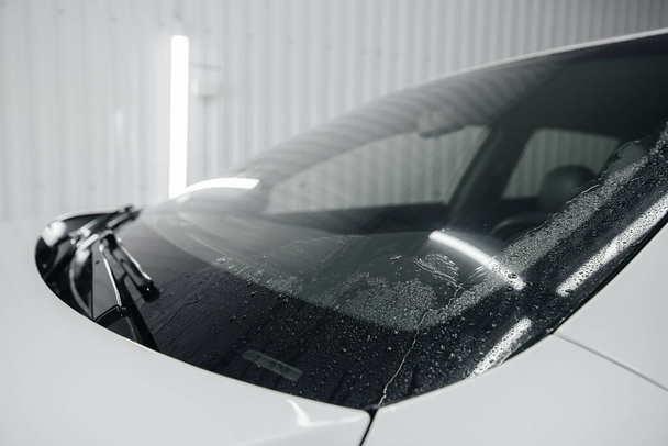 Modern washing with foam and high-pressure water of a white car. Car wash - Foto, Imagem