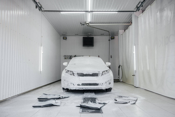 泡と白い車の高圧水で近代的な洗浄。洗車場 - 写真・画像