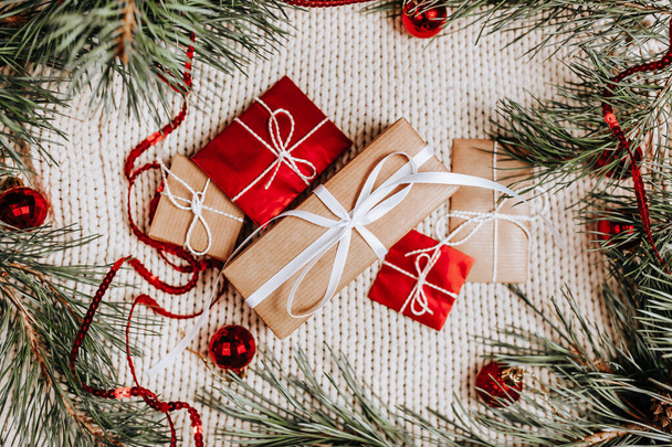 Новогодние подарки на трикотажном фоне с елкой и игрушками - Фото, изображение
