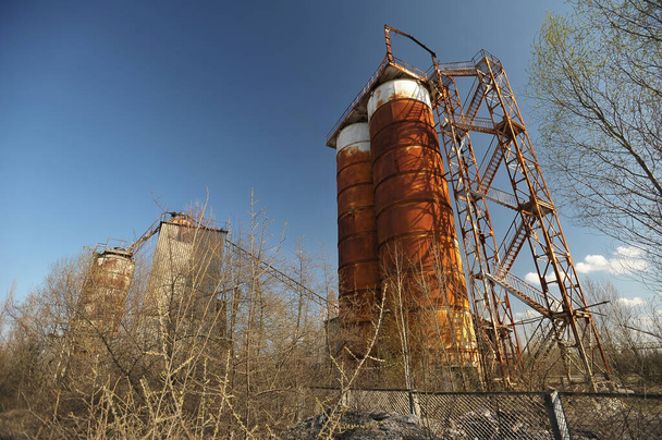 Planta hormigonera oxidada abandonada cerca de la central nuclear de Chernobyl en Ucrania, primavera en la zona de Chernobyl - Foto, Imagen