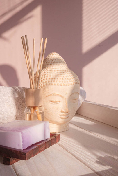Weiße Buddha-Büste auf pastellrosa Hintergrund mit Schattierungen verziert. Null Abfall Bambuszahnbürste. Spa im asiatischen Stil. Entspannte Stimmung. Yoga-Hintergrund. Umweltfreundlich. Hochwertiges Foto - Foto, Bild
