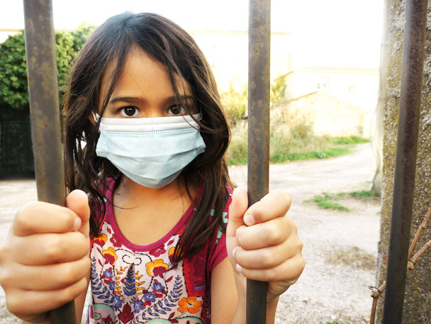 Foto de una niña usando una máscara y sosteniendo barras - Foto, imagen