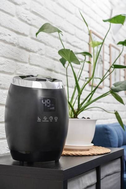 Ultrasonic cool mist humidifier for home on a small table in living room  - Foto, Bild