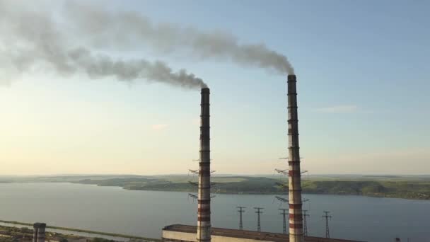 Luchtfoto van hoge schoorsteenpijpen met grijze vuile rook van kolencentrales. Productie van elektriciteit met fossiele brandstoffen. - Video