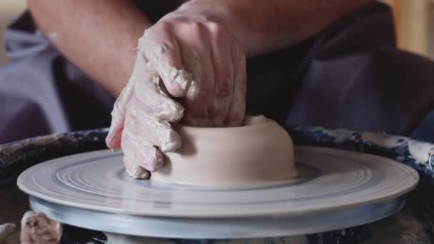 Travail manuel sur roue de poterie, façonnage d'un pot d'argile, marque étudiante de pot d'argile au studio - Séquence, vidéo