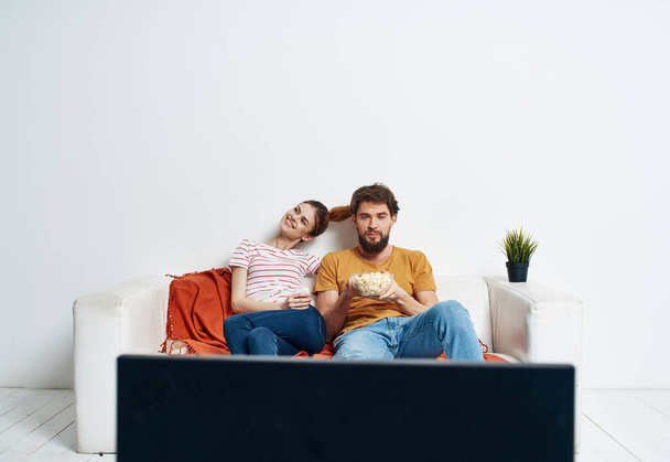 Assistir TV casado casal homem e mulher no sofá e uma flor em um pote - Foto, Imagem