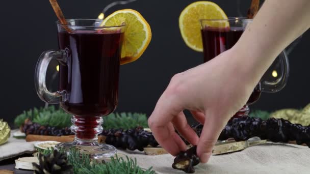 Ένα γυναικείο χέρι βάζει την Churchkhela στο τραπέζι, στο φόντο ενός χριστουγεννιάτικου ποτού με ένα πορτοκάλι - Πλάνα, βίντεο