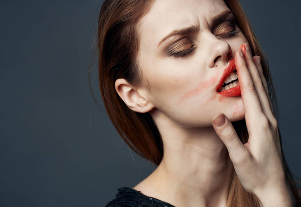 Viehättävä nainen tahraa huulipunaa kasvoilleen - Valokuva, kuva