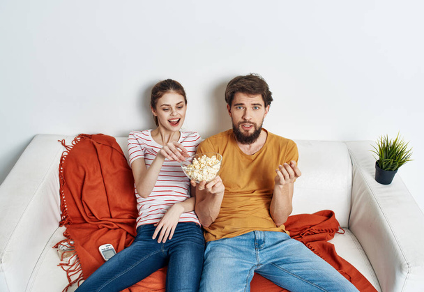 Miehet naiset popcornit lautasella sisällä sohvalla - Valokuva, kuva