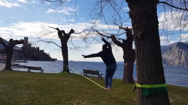 Ιταλία, malcesine, περπατώντας σε μια ισορροπία σε ένα σχοινί κοιτάζοντας τη λίμνη, το ρομαντικό tightrope walker - Πλάνα, βίντεο